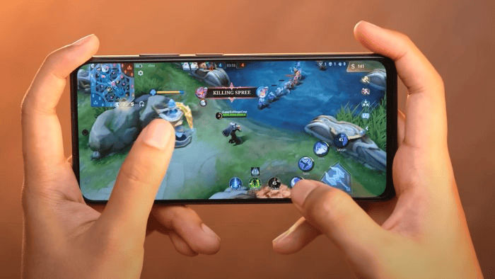 Tangan sedang memegang smartphone dan sedang bermain game mobile legends.